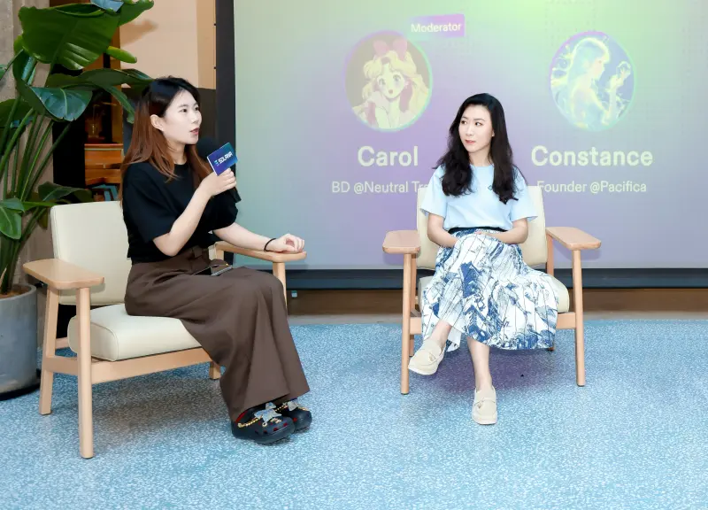 Constance Waing speaking on a panel discussion seated in an armchair.